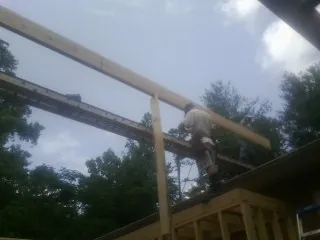 Carpenter setting a ridge beam over a new addition frame — Ice Dam Removal by Roofing Brothers in Eagle Bend