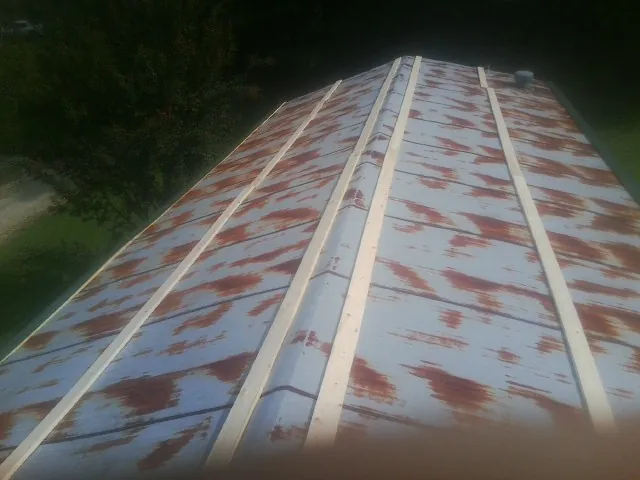 Rusted metal roof panels with new wood purlins before replacement — Storm Damage Roof Repair in Eagle Bend by Roofing Brothers