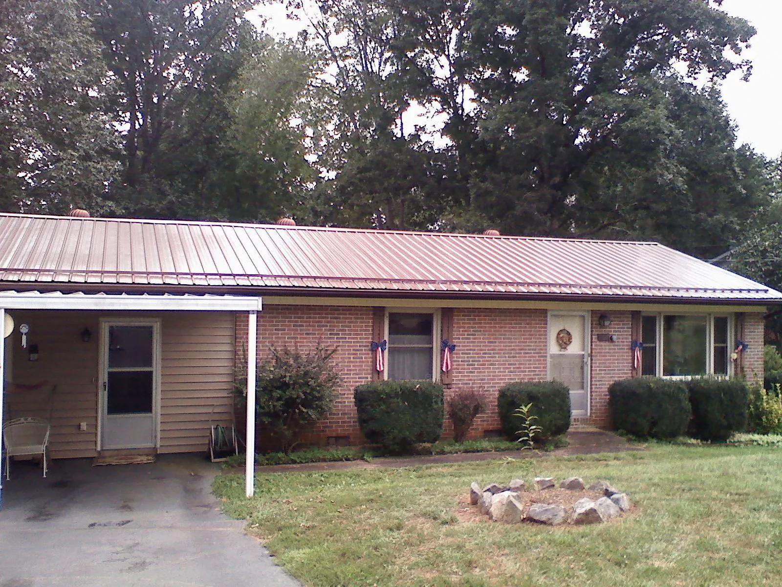 Bronze metal roof and carport on a brick ranch home — Roof Repair work by our crew in Eagle Bend